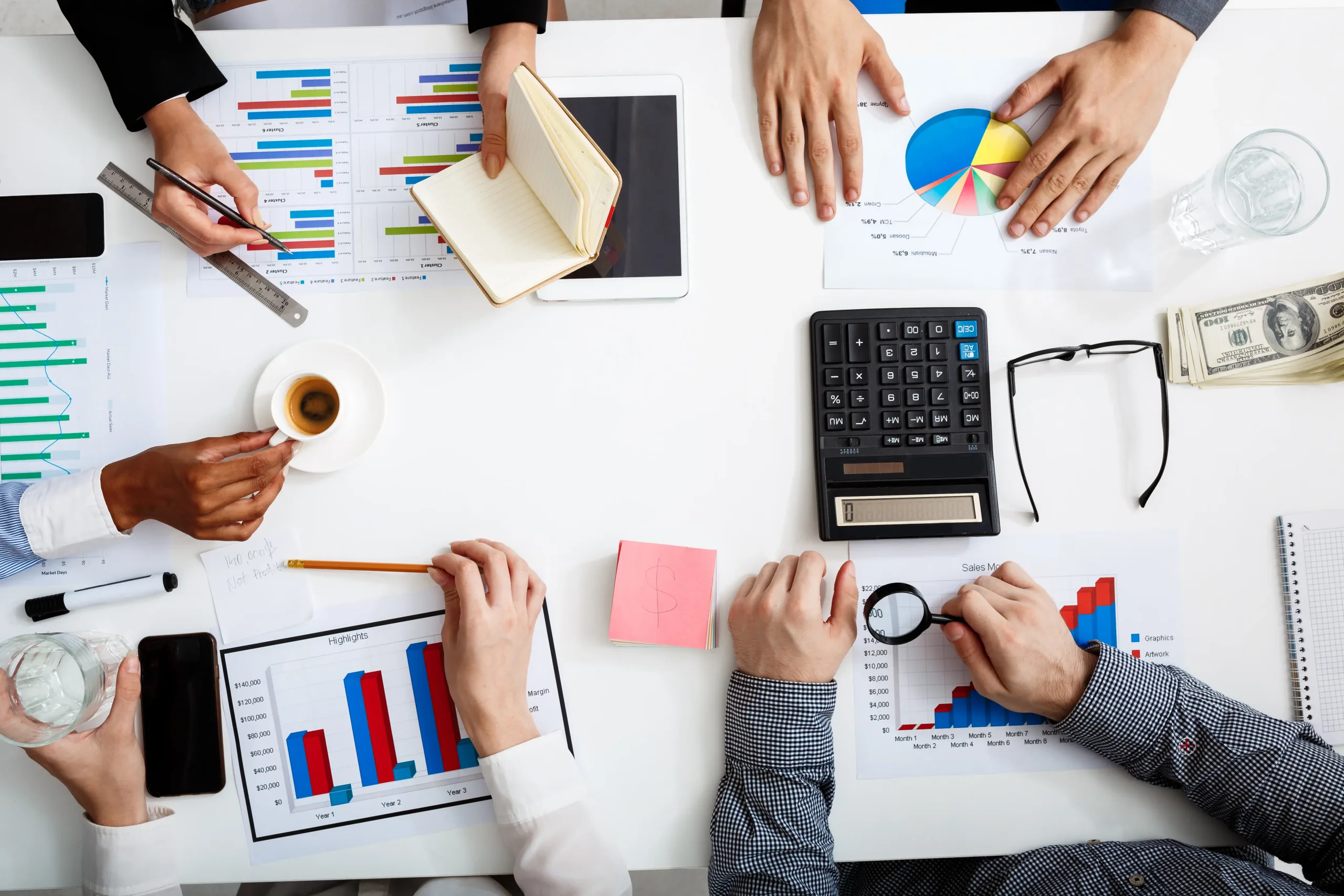 empresarios manos en mesa blanca con documentos y borradores scaled
